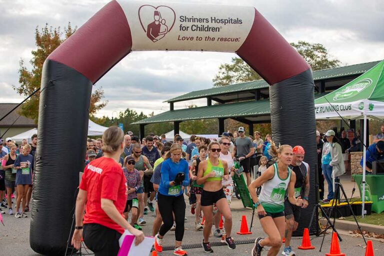runners coming through finish line arch