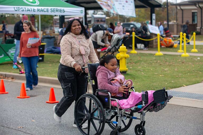 a woman pushing a young girl in wheelchair