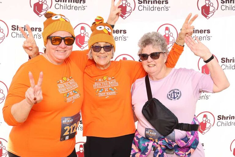 Three women smiling and making peace signs