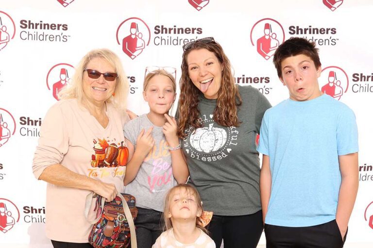 Two women and three children smiling