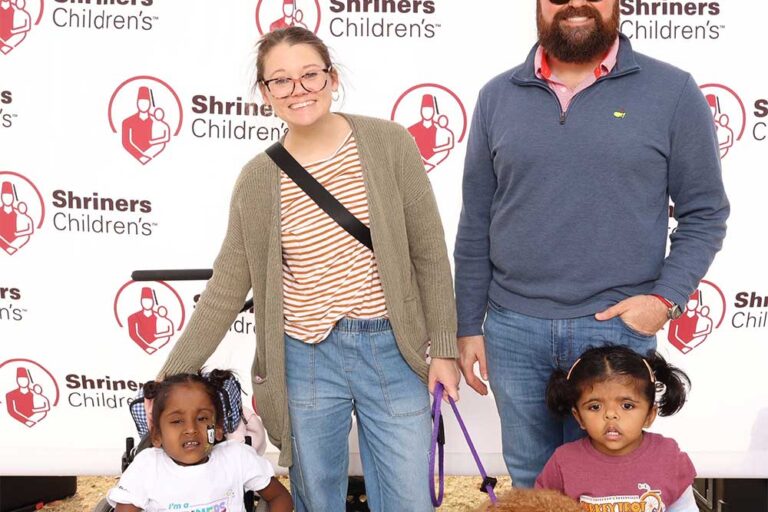 Man and woman with two young children smiling