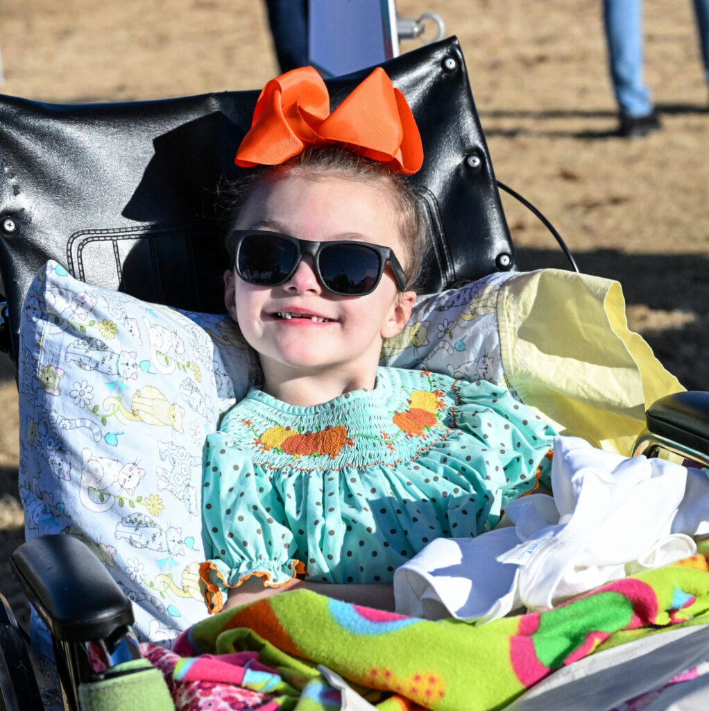 a child wearing a bow and sunglasses
