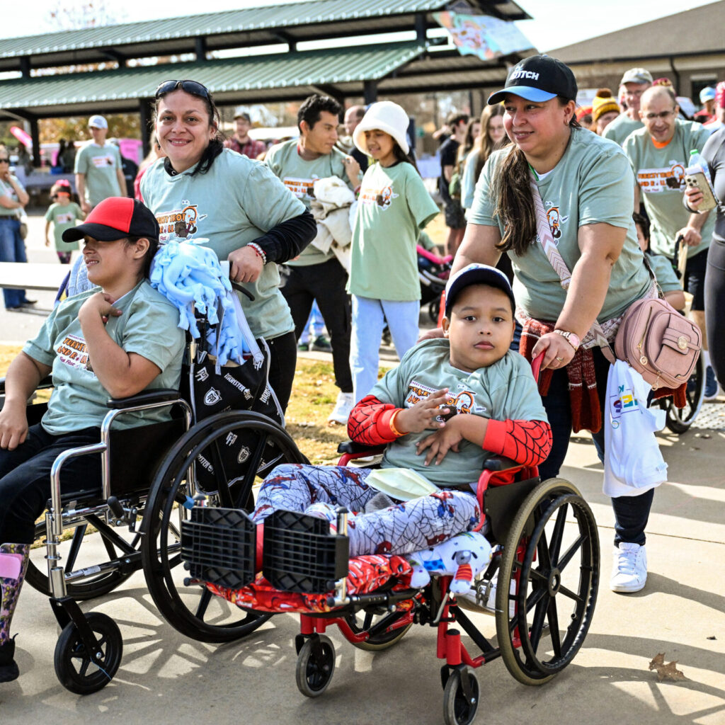 group of people pushing children in wheelchairs